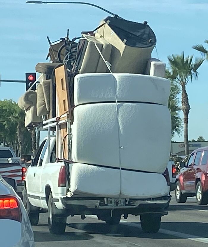 Pickup truck overloaded with bulky furniture causing moving fail