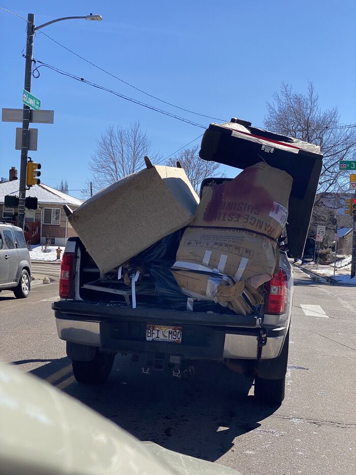 Pickup truck overloaded with bulky furniture spilling out in moving fails