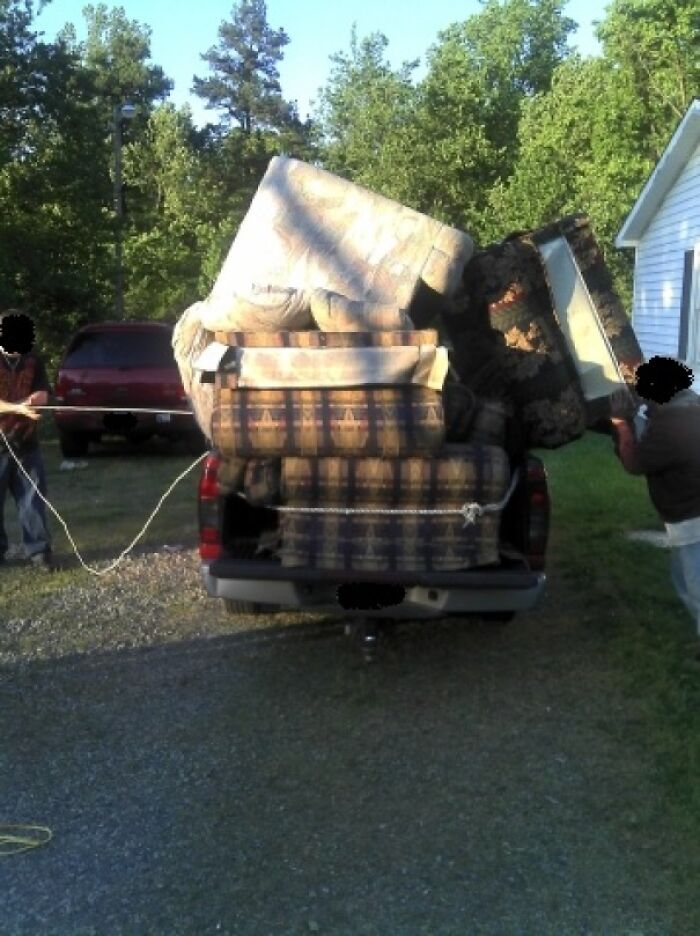Pickup truck overloaded with furniture secured with ropes in moving fail