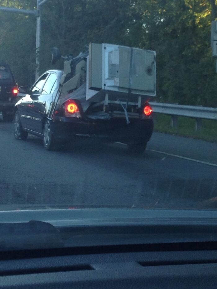 Car improperly transporting large appliances in moving fails image
