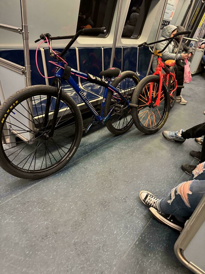 Two bicycles blocking the walkway inside a subway car, showcasing public transport interactions