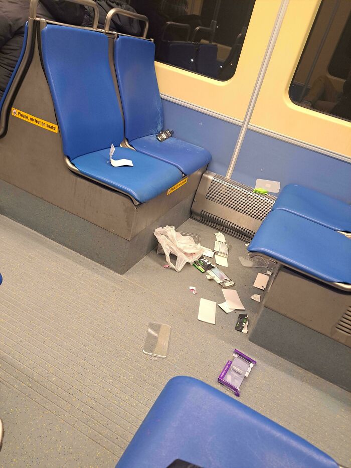 Trash and plastic wrappers scattered on a train floor, showing poor public transport interactions.