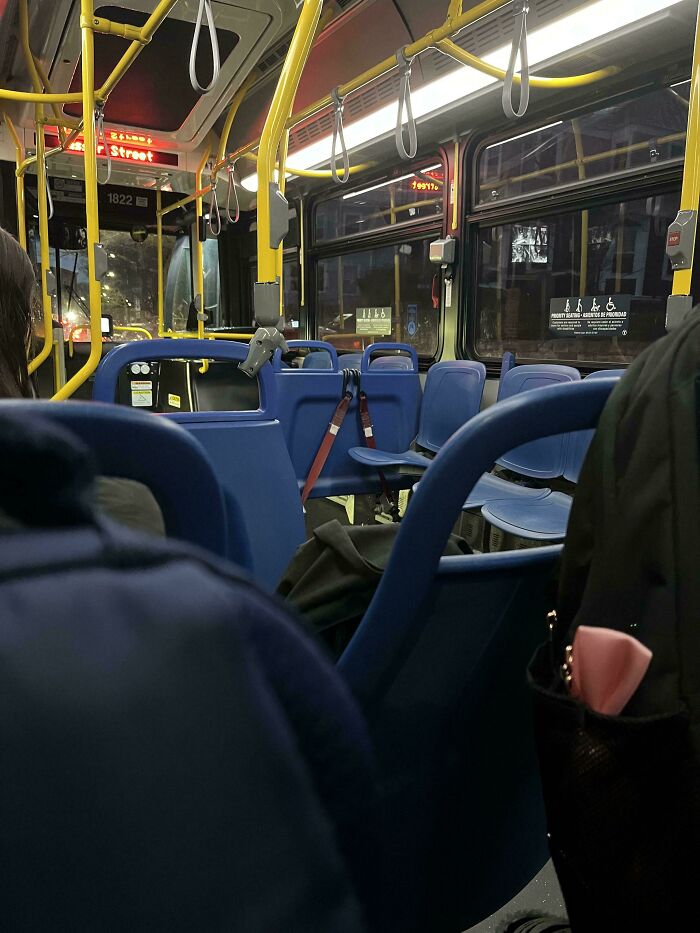 Interior of a city bus with empty blue seats, highlighting public transport interactions.