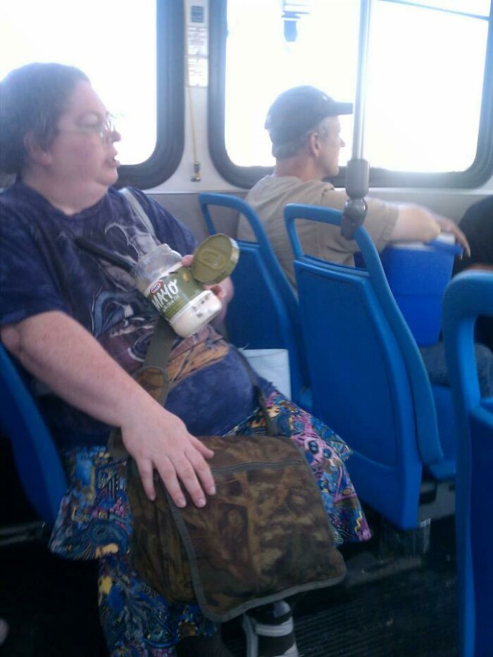 A woman eating from a jar of mayonnaise on a bus, showing strange public transport interactions.