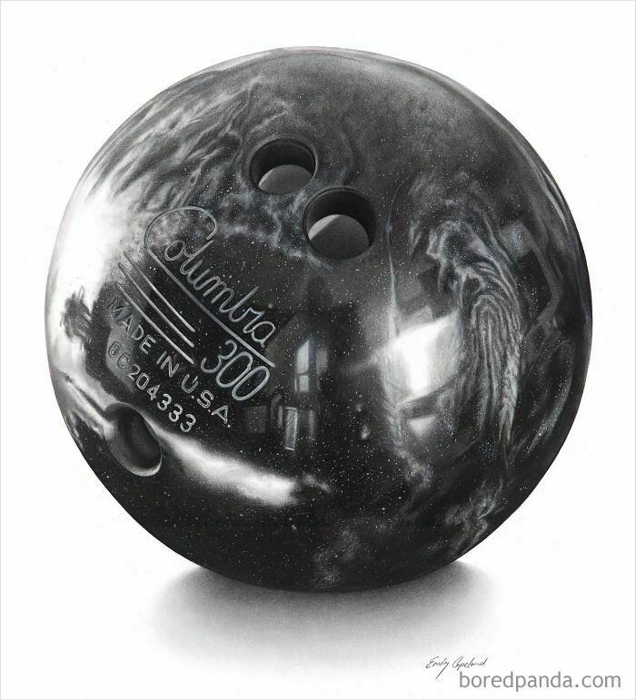 Close-up of vintage Columbia 300 black bowling ball with finger holes and glossy surface