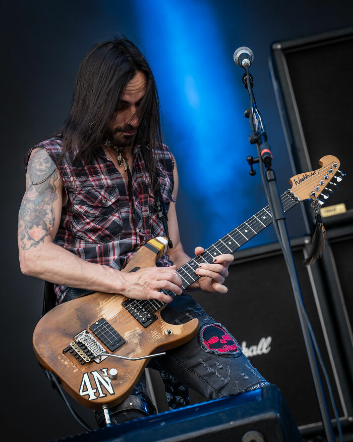 Guitarist Nuno Bettencourt performing live on stage with his signature guitar