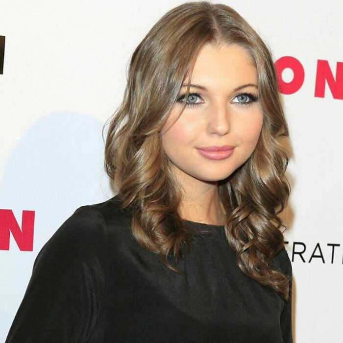 Actress Sammi Hanratty smiling with wavy brown hair at a red carpet event