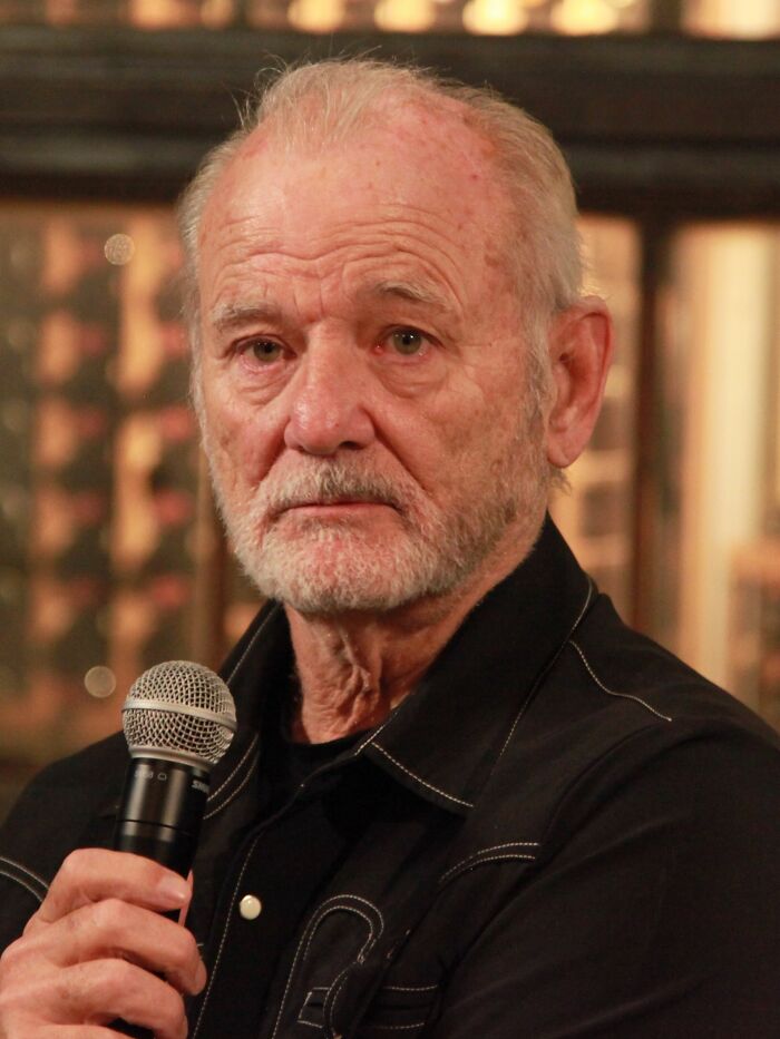 Actor Bill Murray holding a microphone during a public appearance.