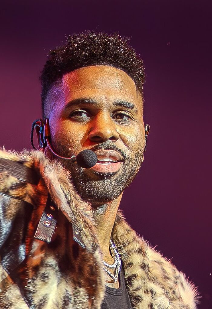 Close up of Jason Derulo performing live with a headset microphone, showing career highlights as a musician.