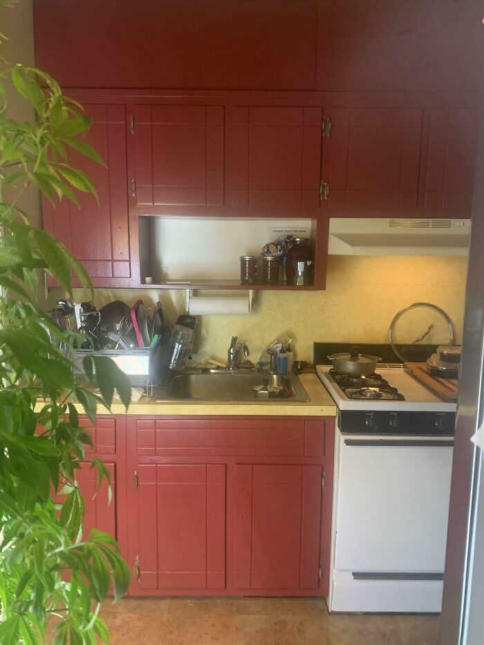 Red painted wooden kitchen cabinets and a sink area, highlighting colorful DIY home upgrades.