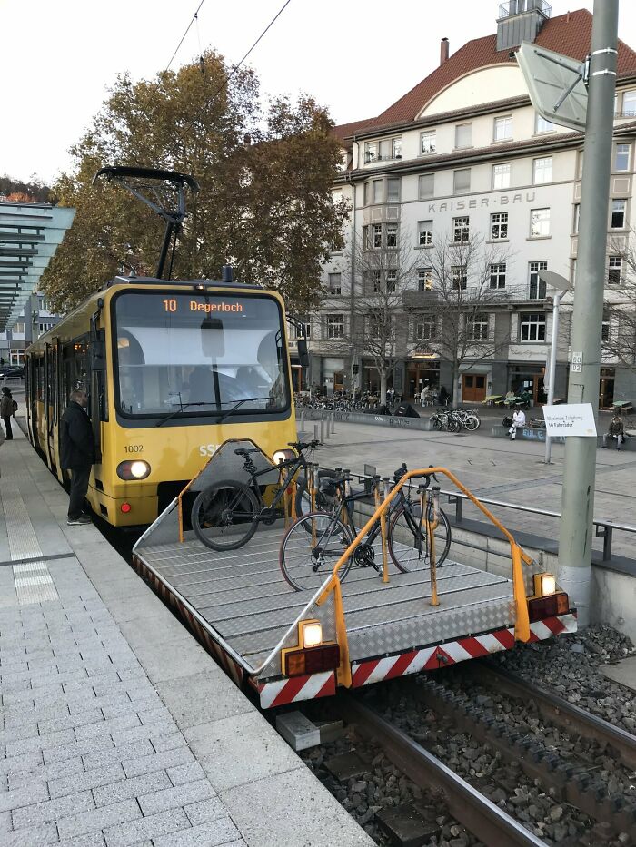 A yellow tram with a built-in bicycle rack on the front showcasing innovative world infrastructure