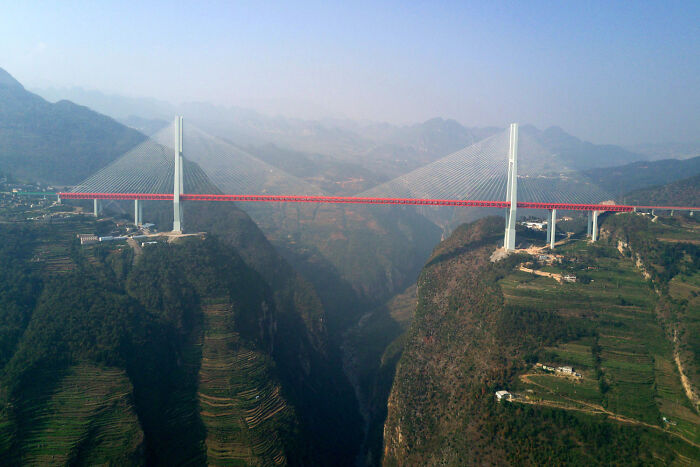 High suspension bridge spanning across a deep canyon, showcasing world's best infrastructure engineering