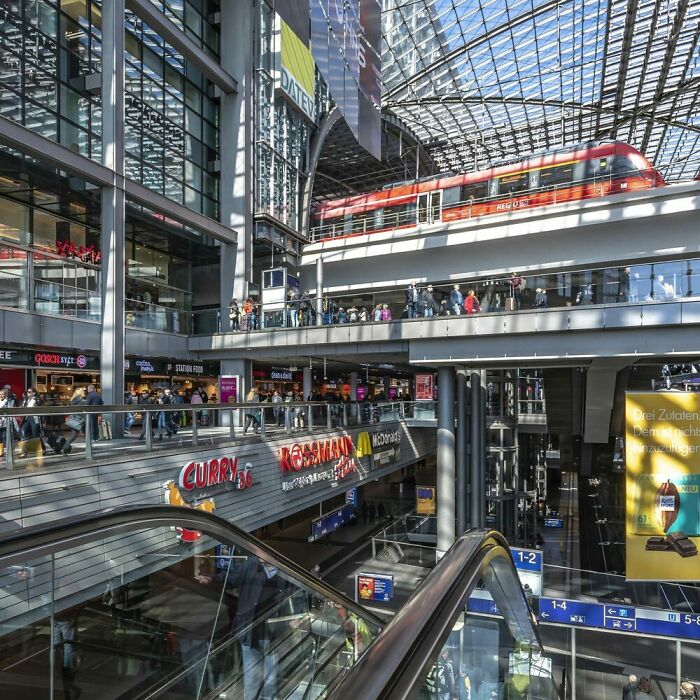 A multi-level modern train station with integrated transit and shopping infrastructure in Berlin.