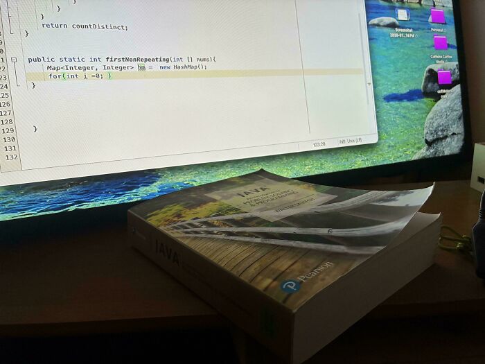 A Java programming textbook on a desk in front of a computer, relating to teachers who took their jobs seriously