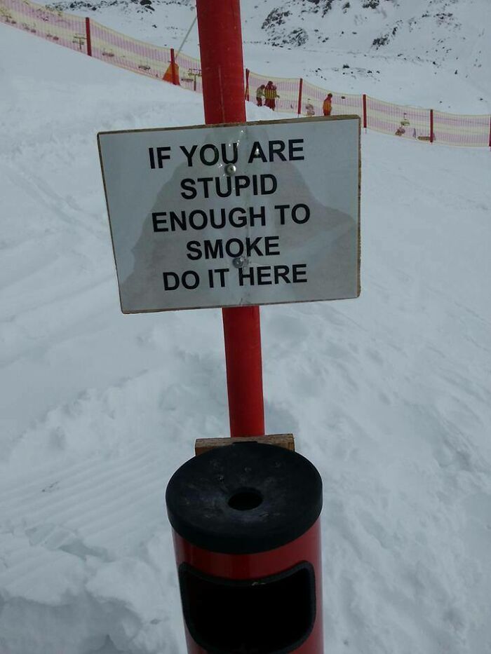 Funny smoking sign on snowy mountain saying stupid smokers should smoke here