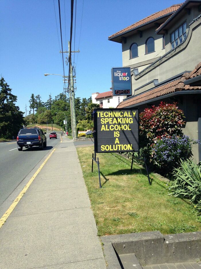 Humorous sign outside liquor store stating alcohol is technically a solution