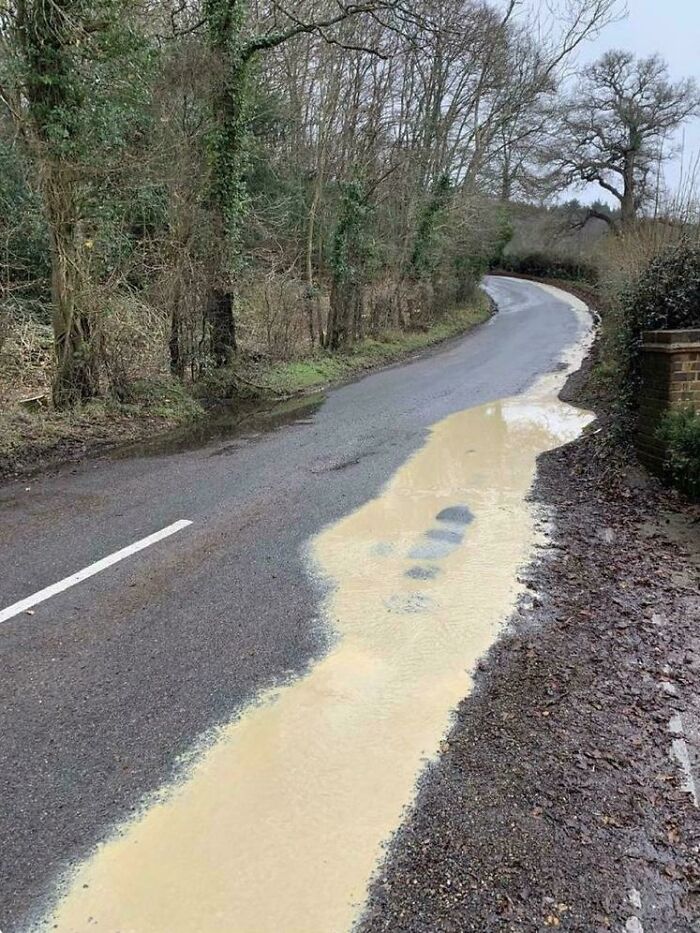 A muddy puddle on a country road highlighting funny British memes about the weather and outdoors