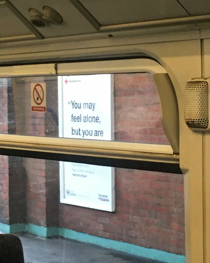 An ironic billboard seen through a train window, representing relatable British memes about isolation.