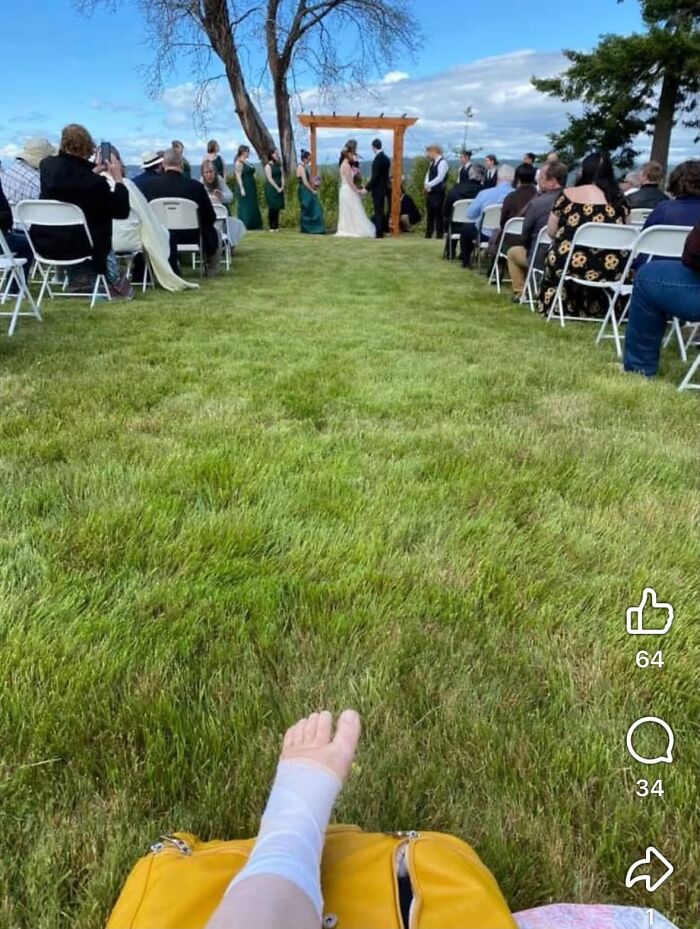 A wedding guest with a bandaged foot watching an outdoor ceremony