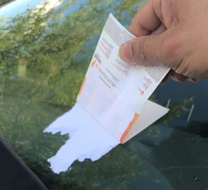Adhesive parking notice tearing and leaving paper residue on a windshield