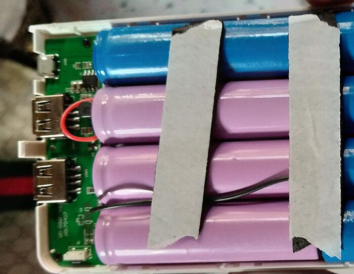 A power bank opened to show batteries taped together, a terrible product design safety hazard