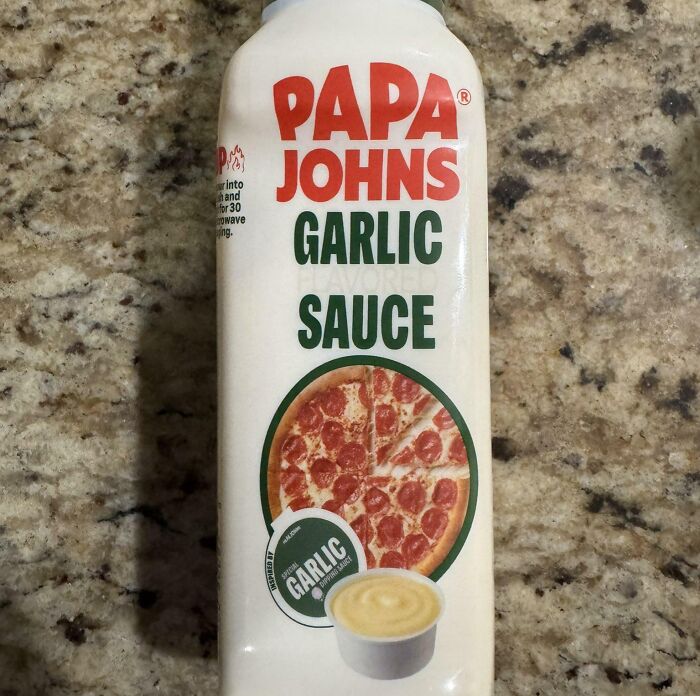 A bottle of Papa Johns Garlic Sauce that has a terrible product design because the bottle cannot stand upside down