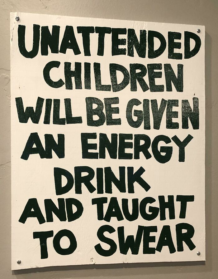 Humorous sign warning unattended children will be given energy drinks and taught to swear