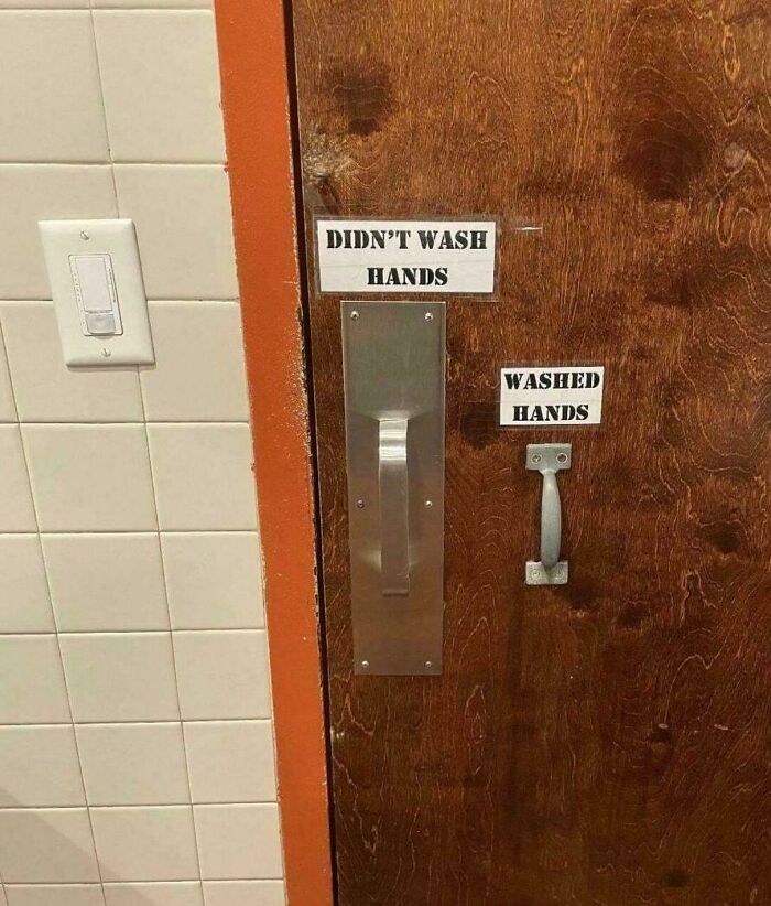 Bathroom door with handles labeled for washed and unwashed hands
