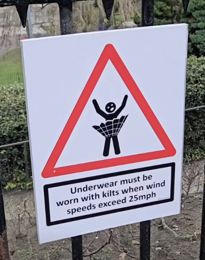 Humorous warning sign requiring underwear with kilts when wind speeds exceed 25 mph