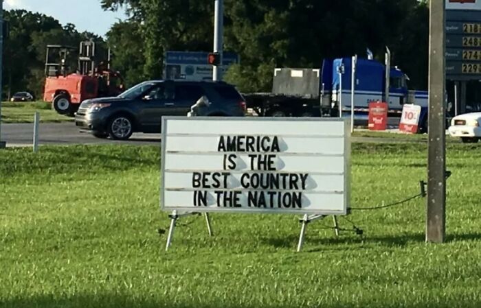 Funny sign reading America is the best country in the nation on roadside lawn