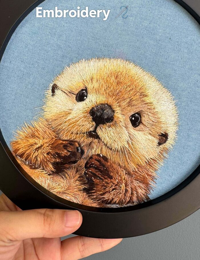 A highly realistic hand-embroidered baby otter, showcasing creative embroidery projects in a round hoop