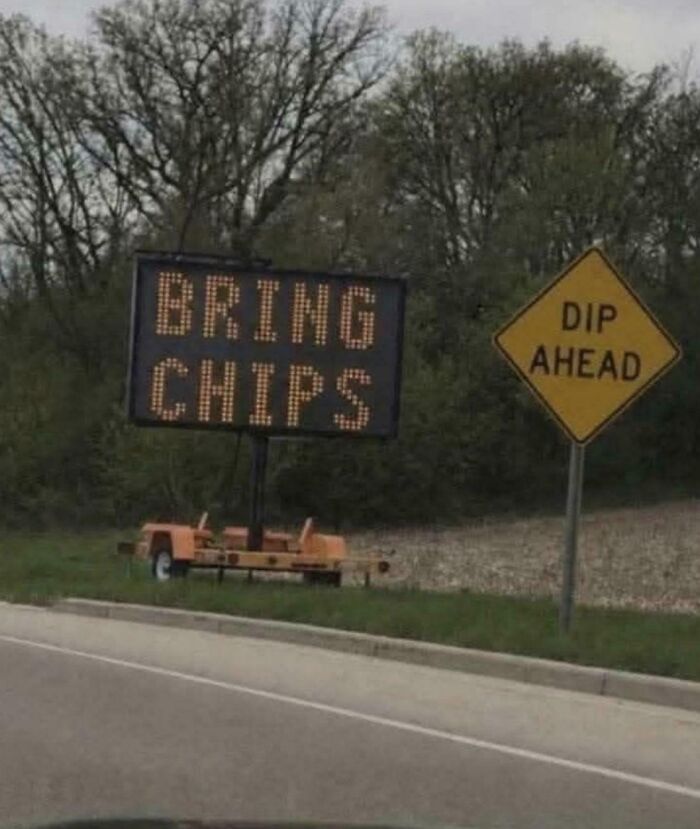 Funny hilarious sign reading bring chips next to dip ahead road sign