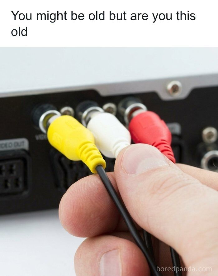 A hand plugging in yellow, white, and red RCA cables, bringing back 90s nostalgic pics memories.