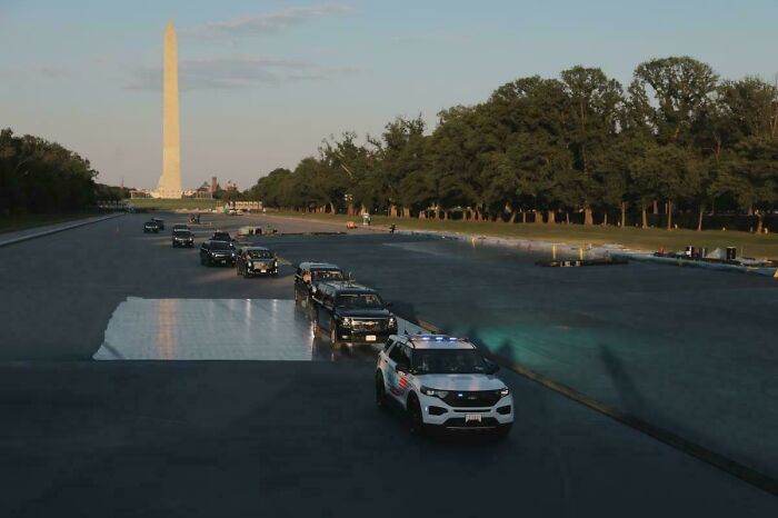 Motorcade driving near Washington Monument symbolizing political security presence