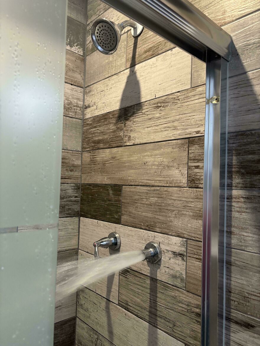 Shower with water spraying horizontally from a faulty faucet fixture