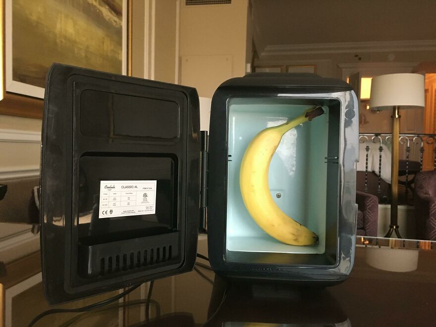 Small mini fridge interior with a single banana on a hotel room desk
