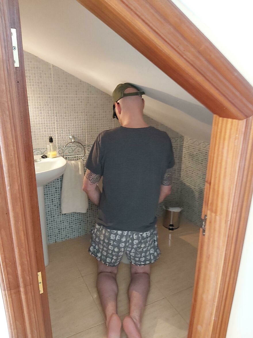 Man unable to stand upright in low ceiling bathroom at Airbnb rental