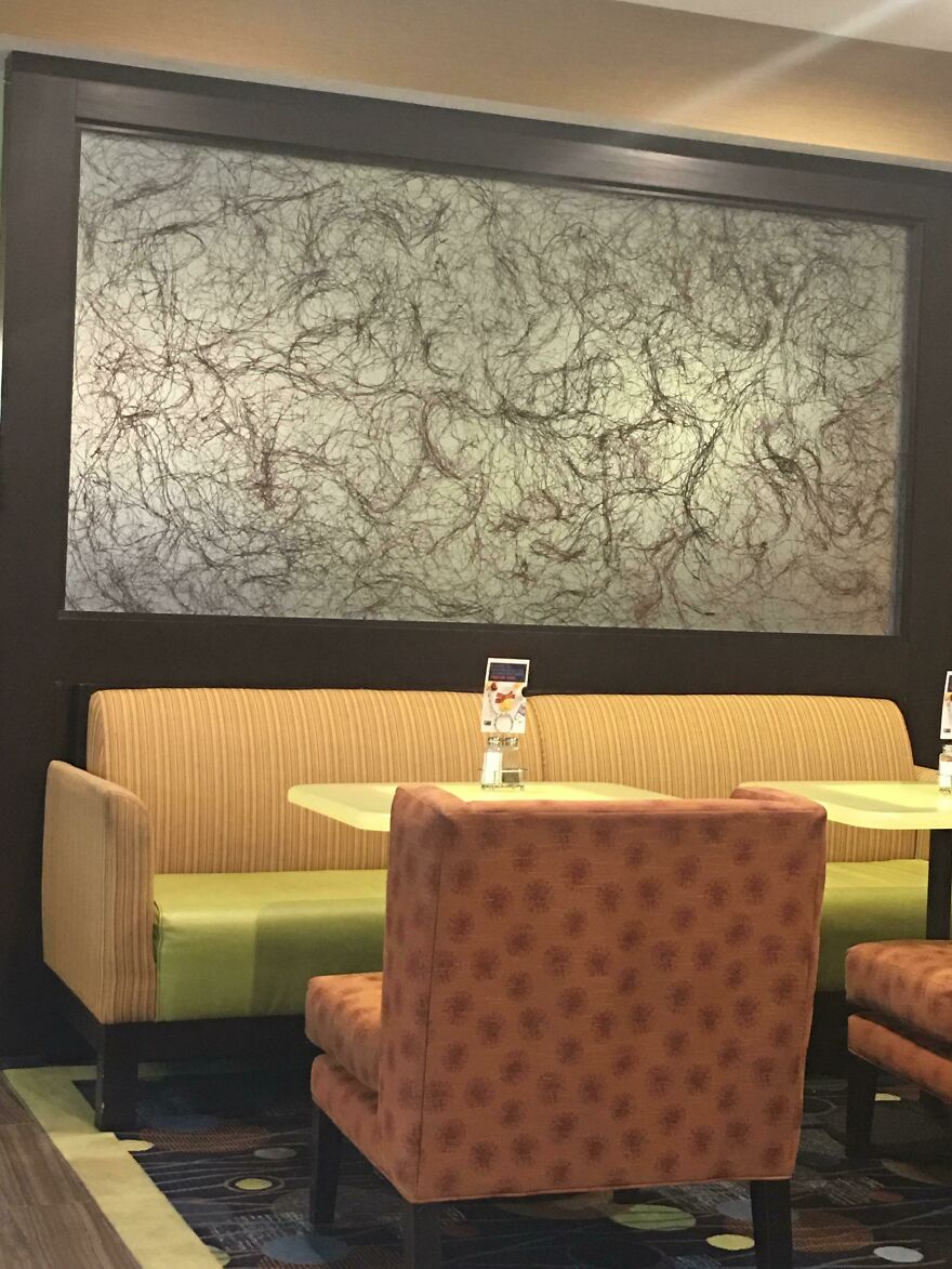 Hotel lounge seating area with abstract hair-like wall art