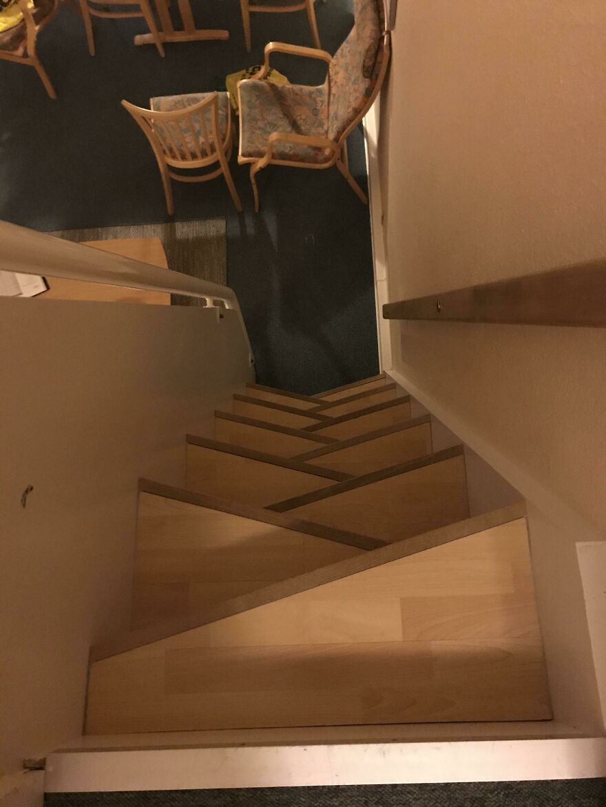 Steep and narrow wooden staircase leading down to hotel lobby area
