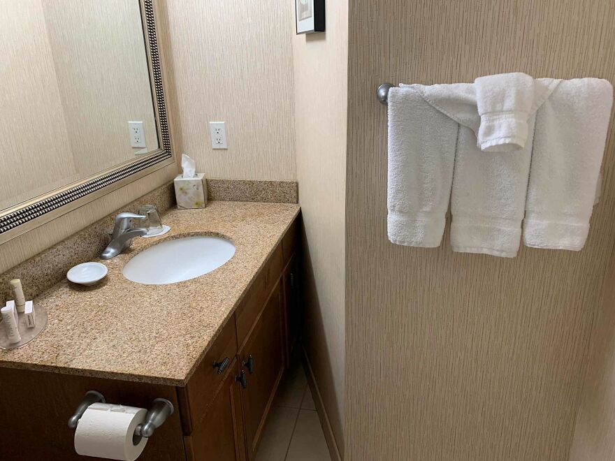 Bathroom sink and towel rack with oddly hung towel hotel fails