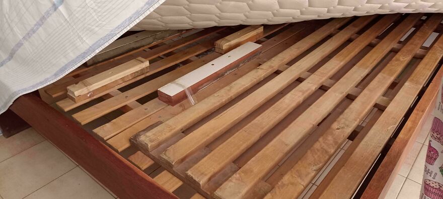 Broken wooden bed frame slats exposed in Airbnb accommodation fail