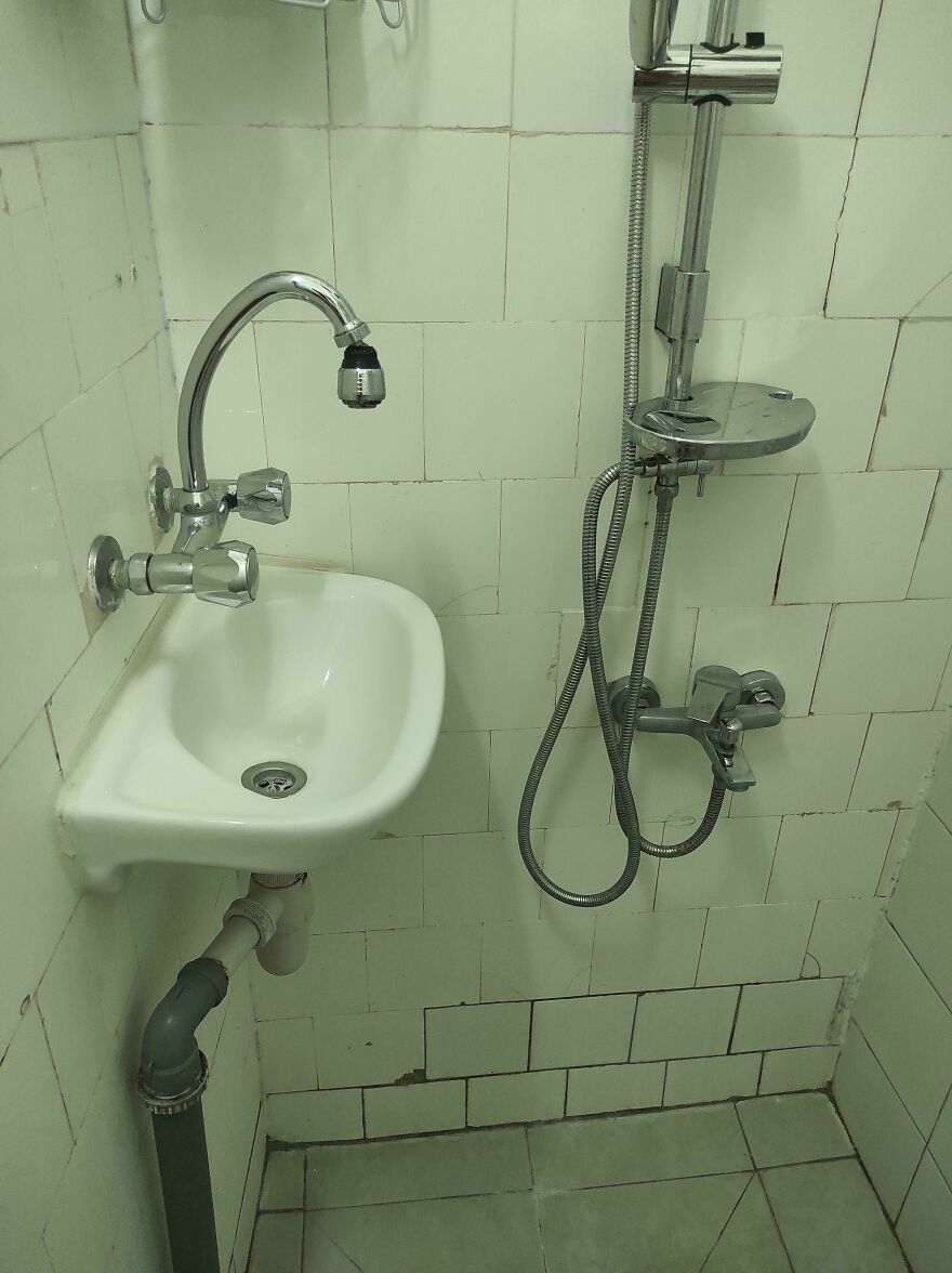 Small bathroom sink and shower installed very close in hotel room