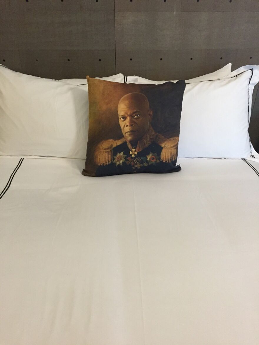 Decorative pillow with portrait on neatly made hotel bed