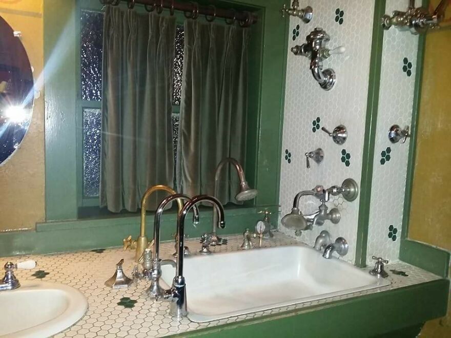 Bathroom sink with multiple faucets and shower fixtures on tiled countertop