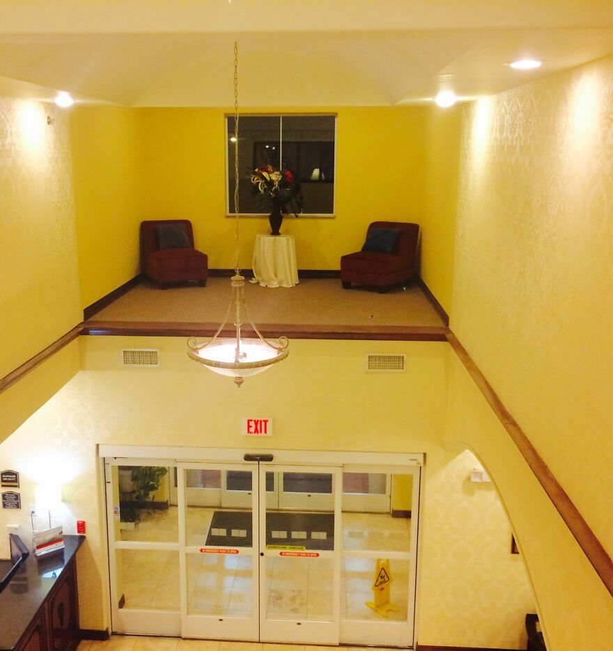 Hotel lobby with an inaccessible elevated seating area above entrance doors