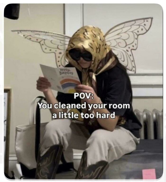 A person dressed in fairy wings and sunglasses holding a card, capturing funny ADHD memes