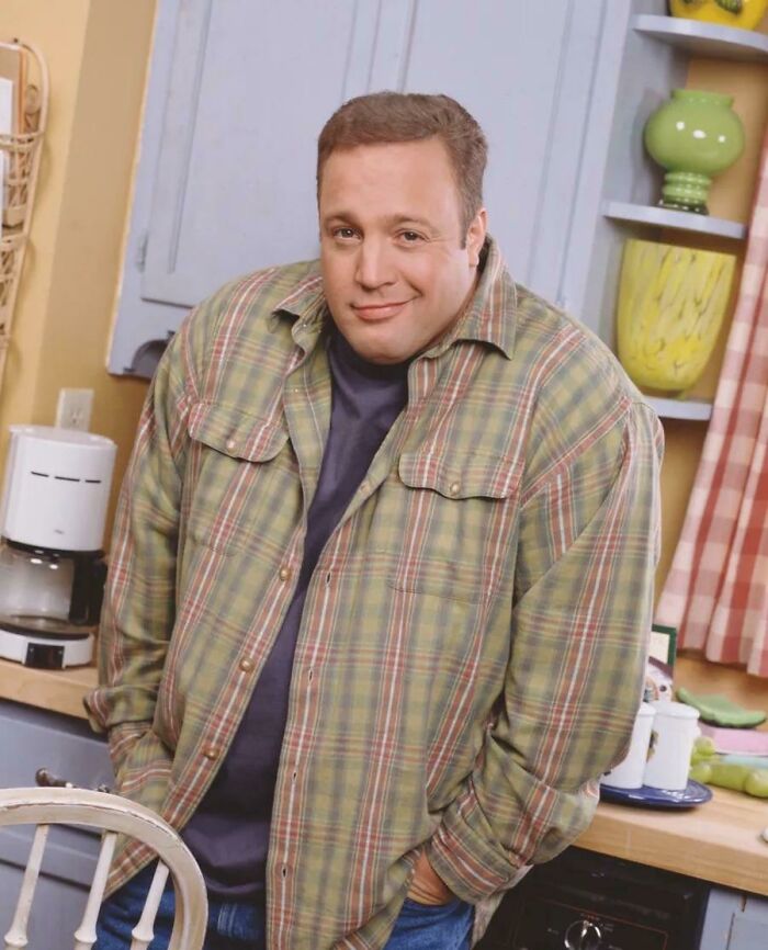 Man smiling in kitchen wearing green plaid shirt