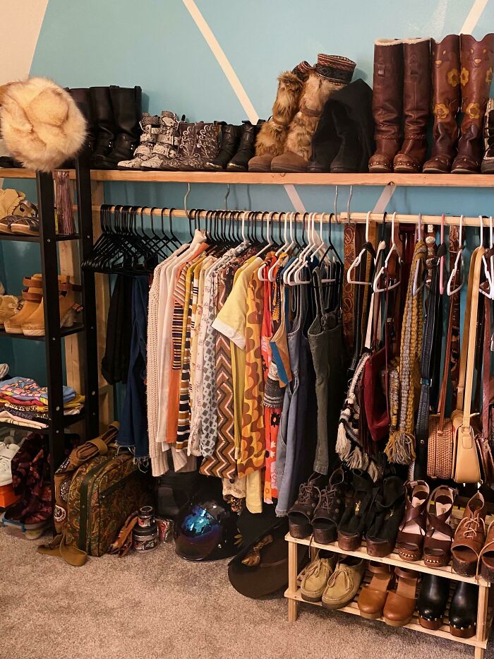 An organized closet filled with vintage clothes, shoes, and bags from various thrift store finds.