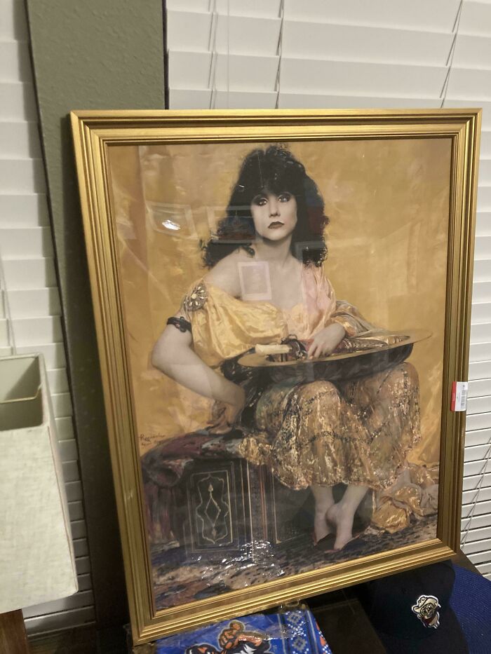 A gold-framed vintage painting found as one of the thrift store finds, depicting a woman in classical attire