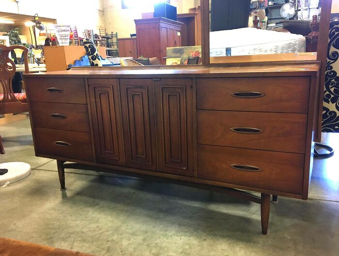 A mid-century modern wooden dresser discovered as one of the best thrift store finds.